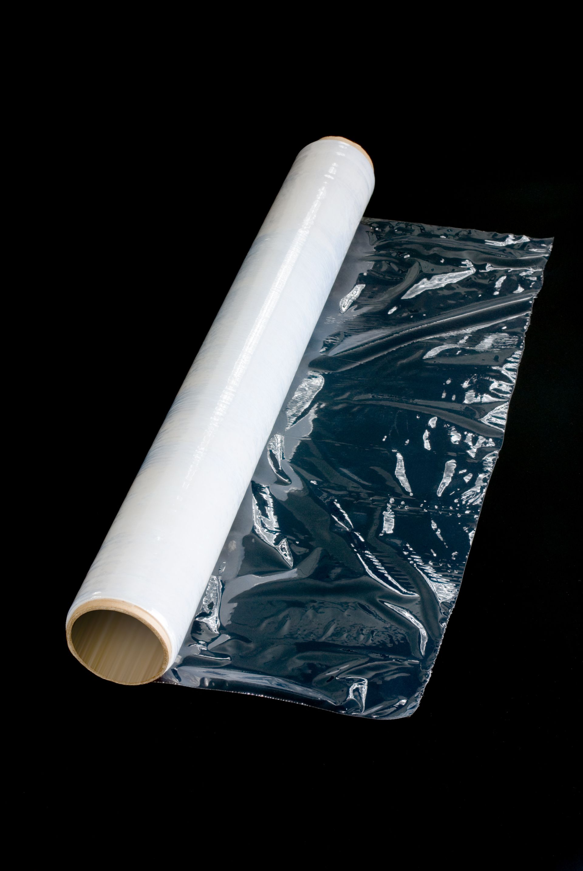 A roll of plastic wrap on a black background.