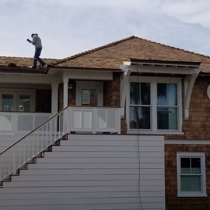 A man is standing on the roof of a house