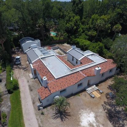 An aerial view of a house with a red tile roof