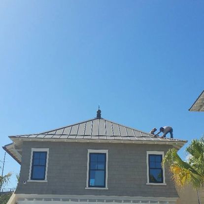 A man is working on the roof of a house.
