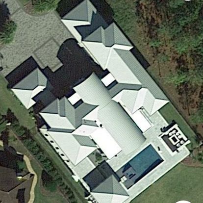 An aerial view of a large house with a pool in the backyard.