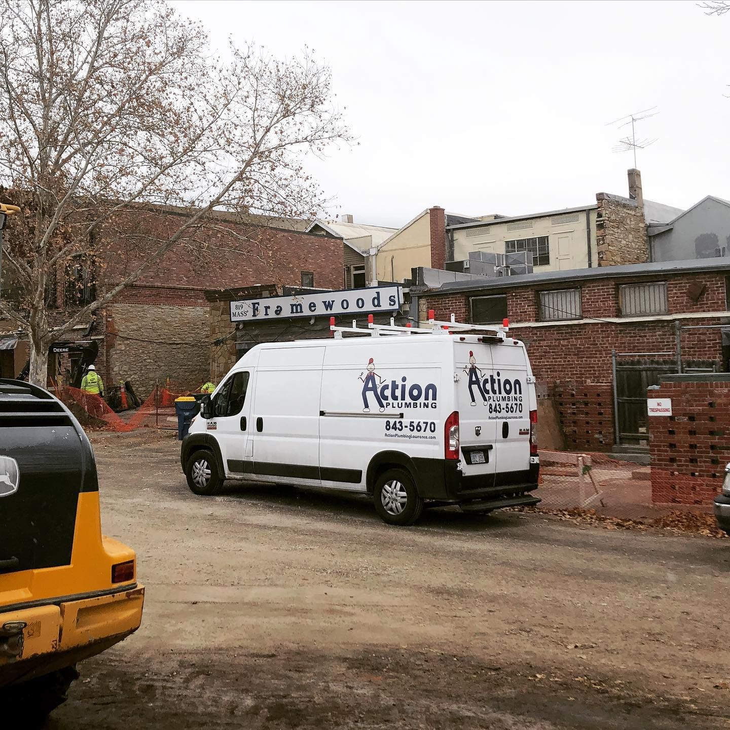 a white van with the words action plumbing on it is parked in front of a building .