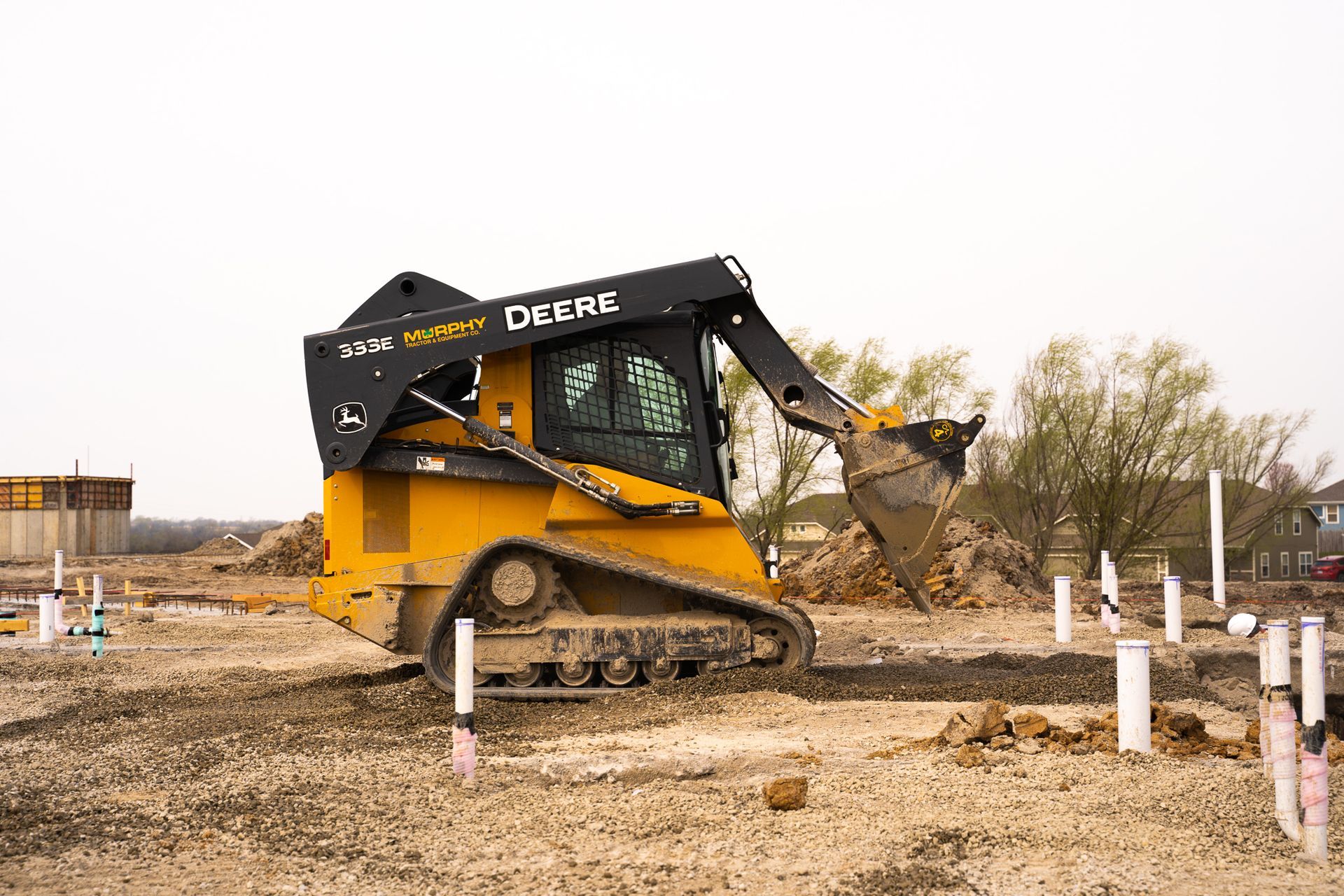 a yellow bulldozer is moving dirt on a construction site .