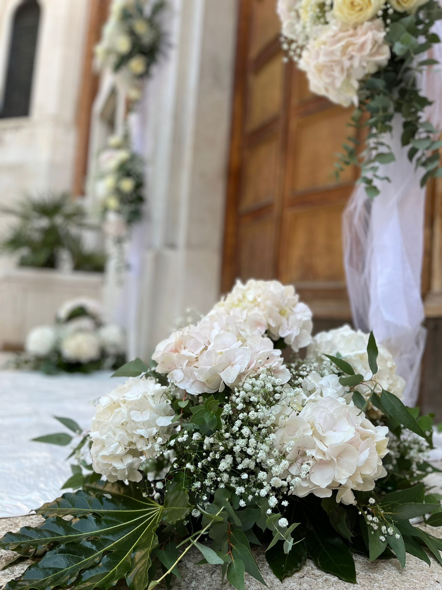 I fiori da matrimonio nei toni del bianco e del verde decorano la porta.