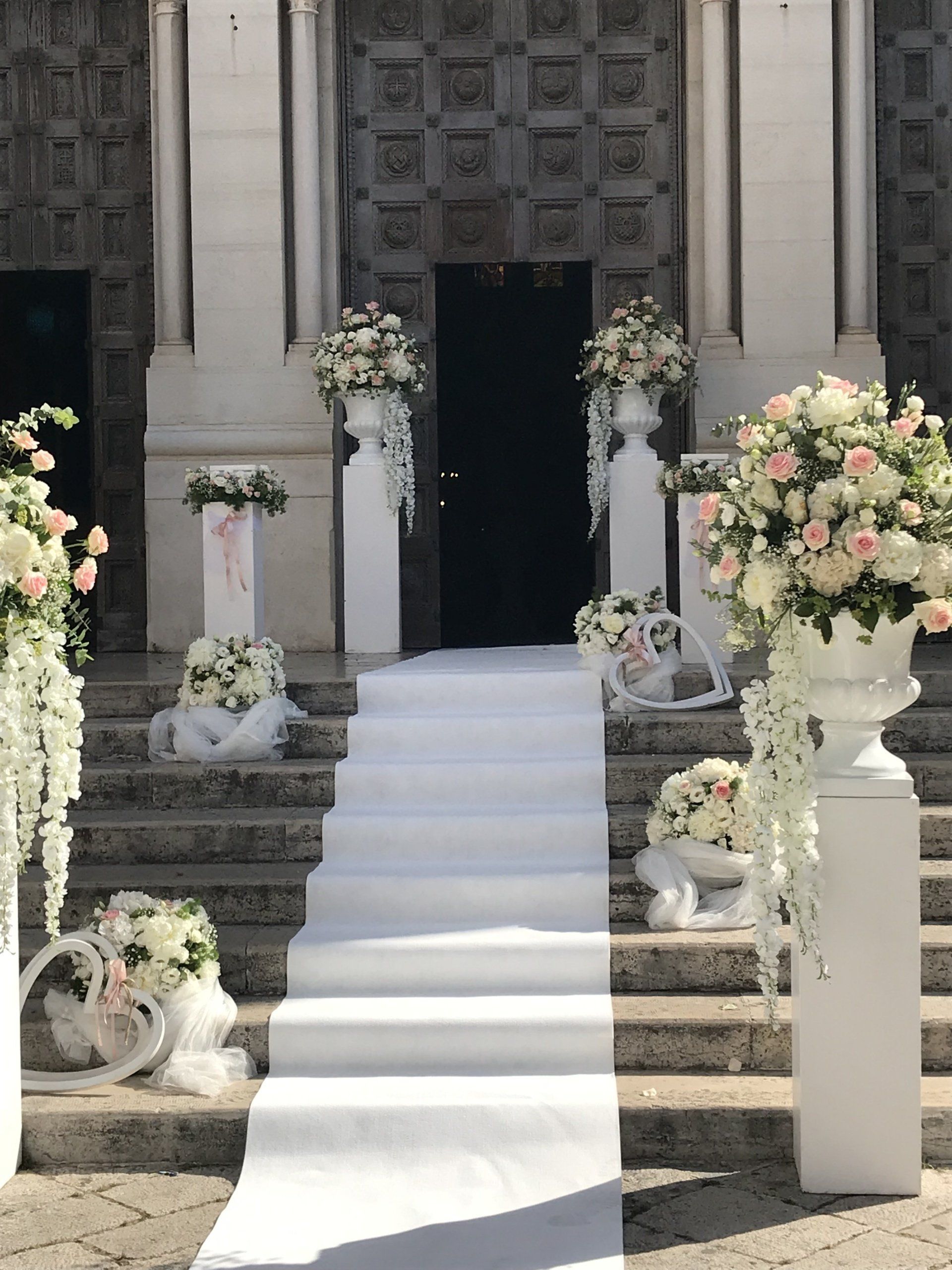 entrata di una chiesa con addobbi bianchi