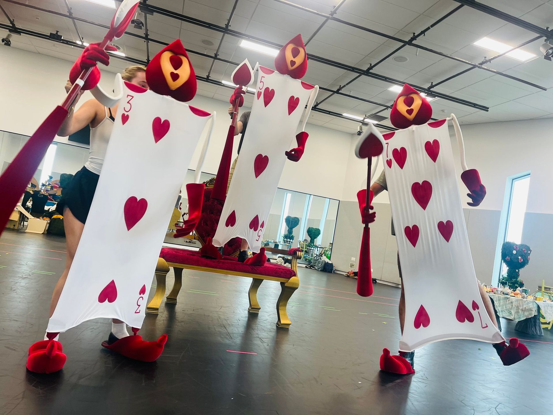 A group of people dressed as queen of hearts are standing in a room.