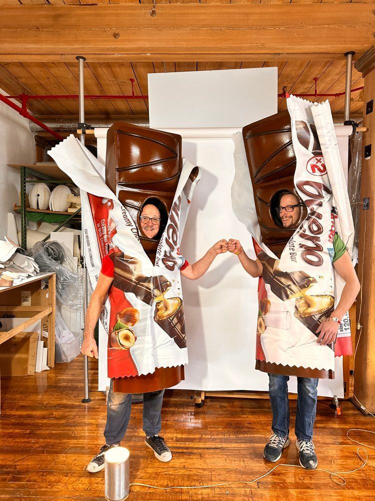 Two people are dressed up as nutella bars and holding hands.