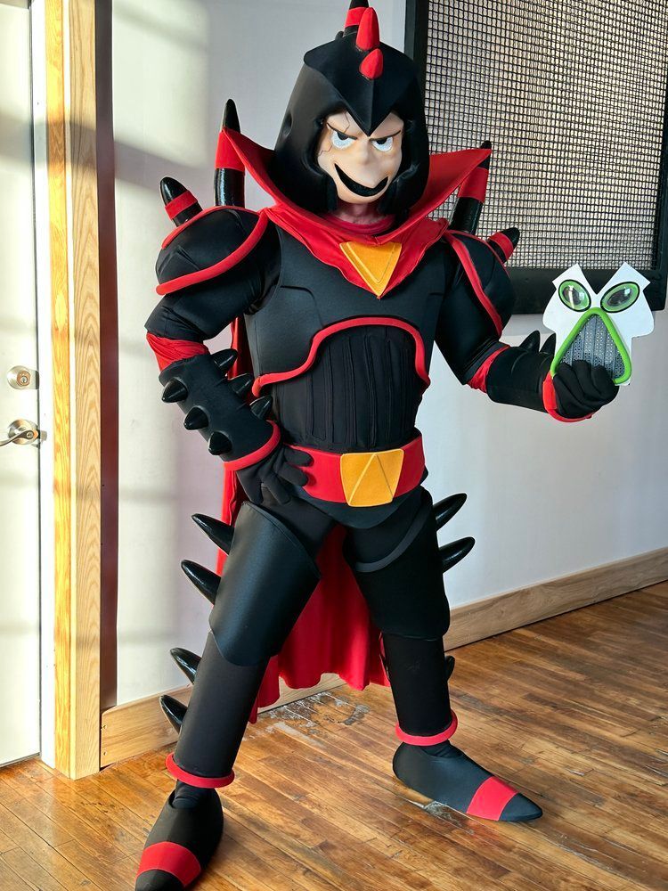 A person in a superhero costume is standing on a wooden floor.