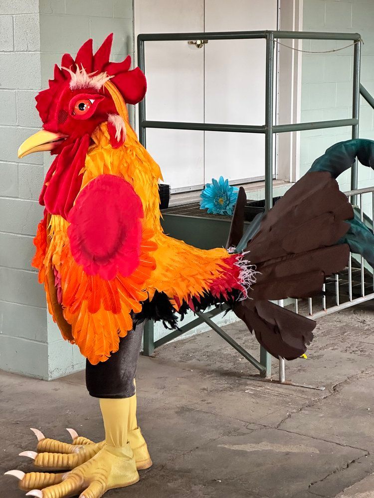 A rooster costume is standing in front of a staircase