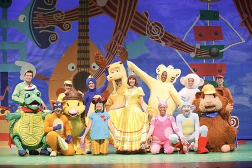 A group of cartoon characters are posing for a picture on a stage