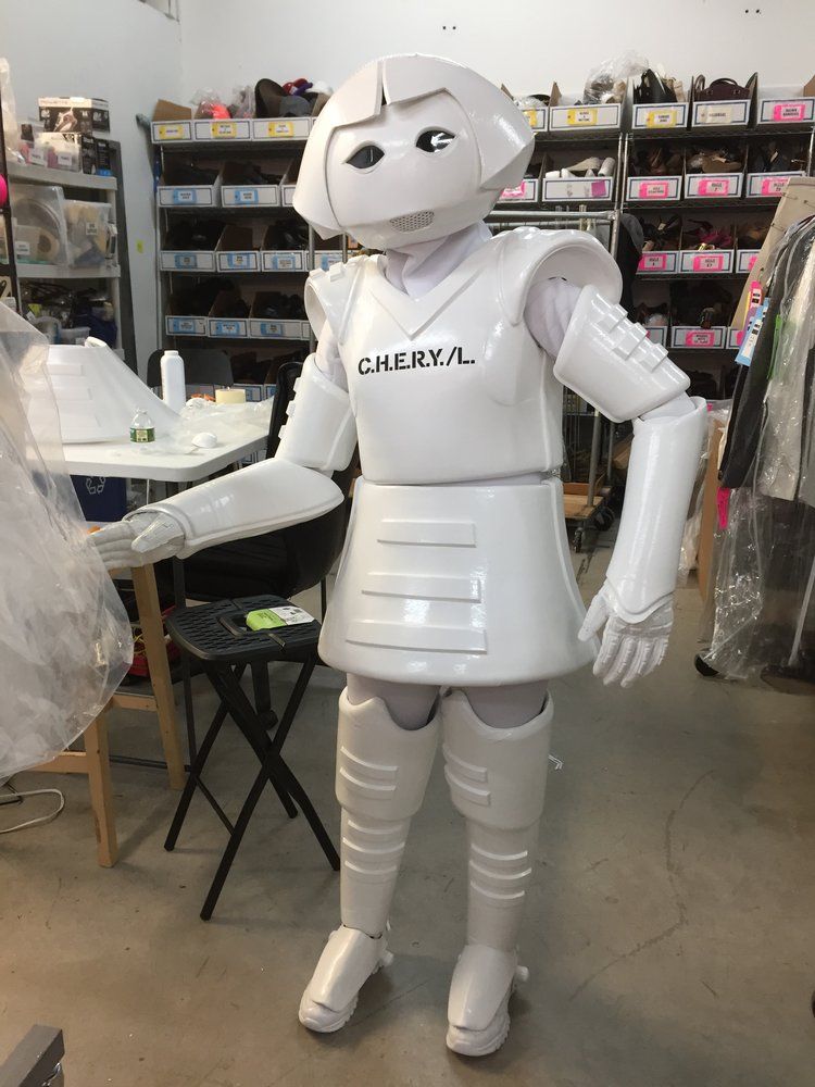 A white robot mascot is standing in a room.