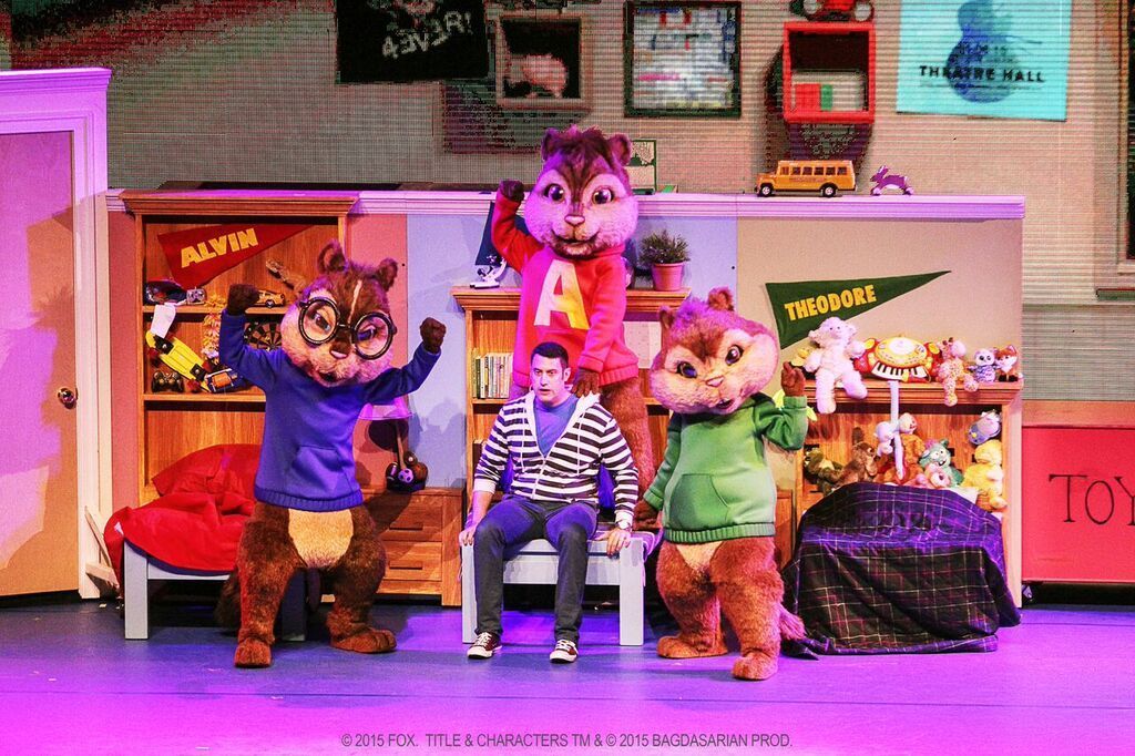 A group of alvin and the chipmunks are standing next to each other on a stage.