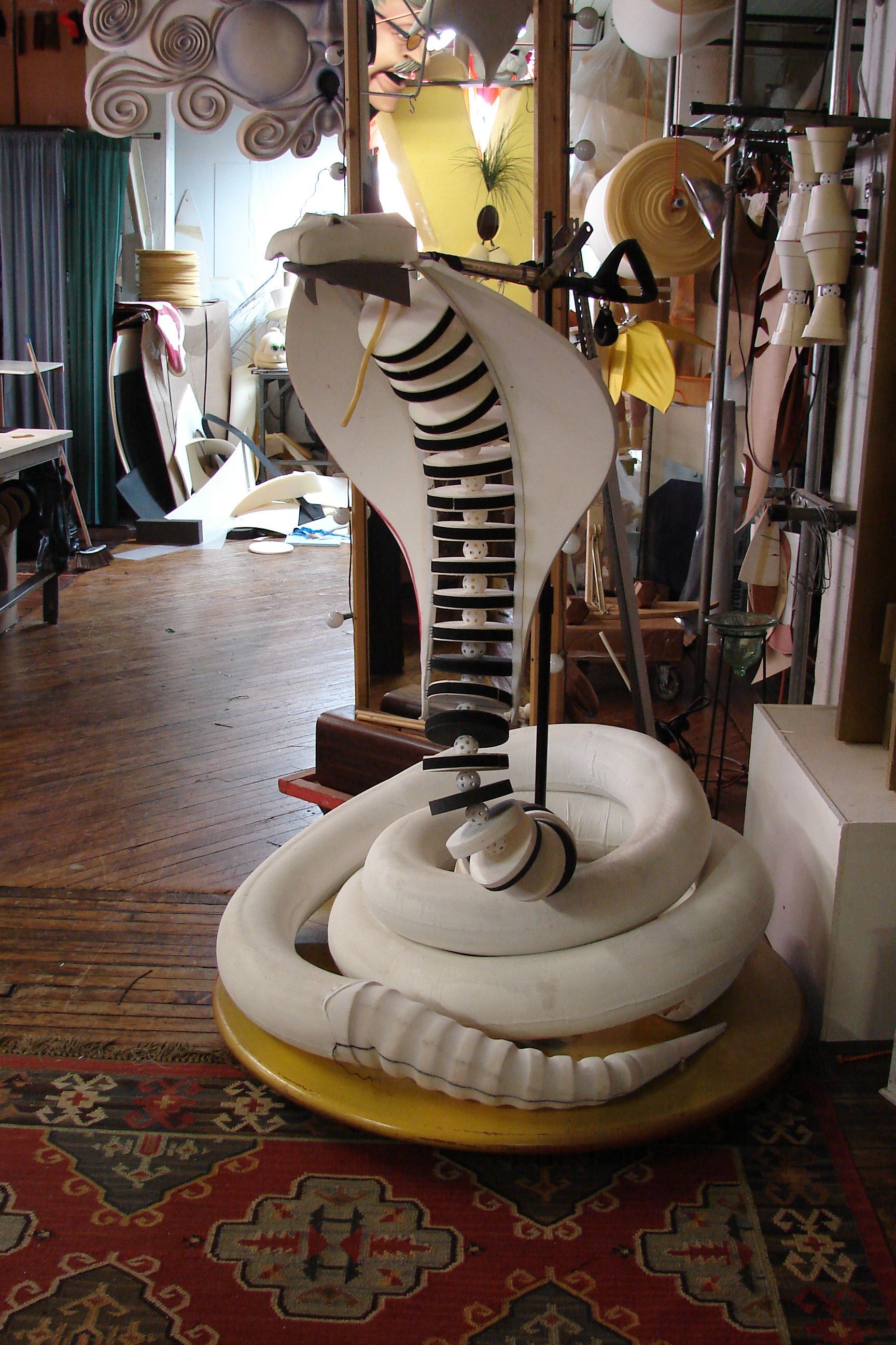 A large white snake statue is sitting on a table in a room.