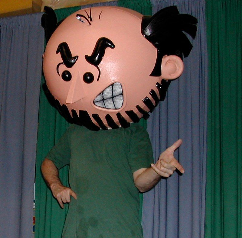 A man in a green shirt has a cartoon head on his head