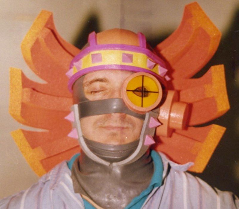 A man wearing a purple and orange helmet and goggles