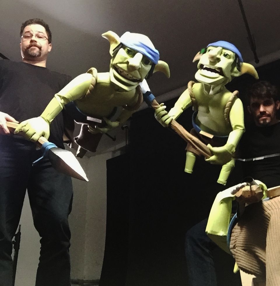 A man standing next to a puppet holding a shovel