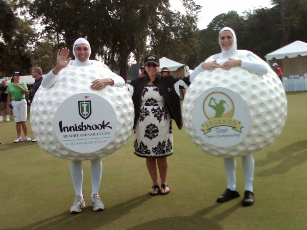 Three people dressed as golf balls with innisbrooks written on them