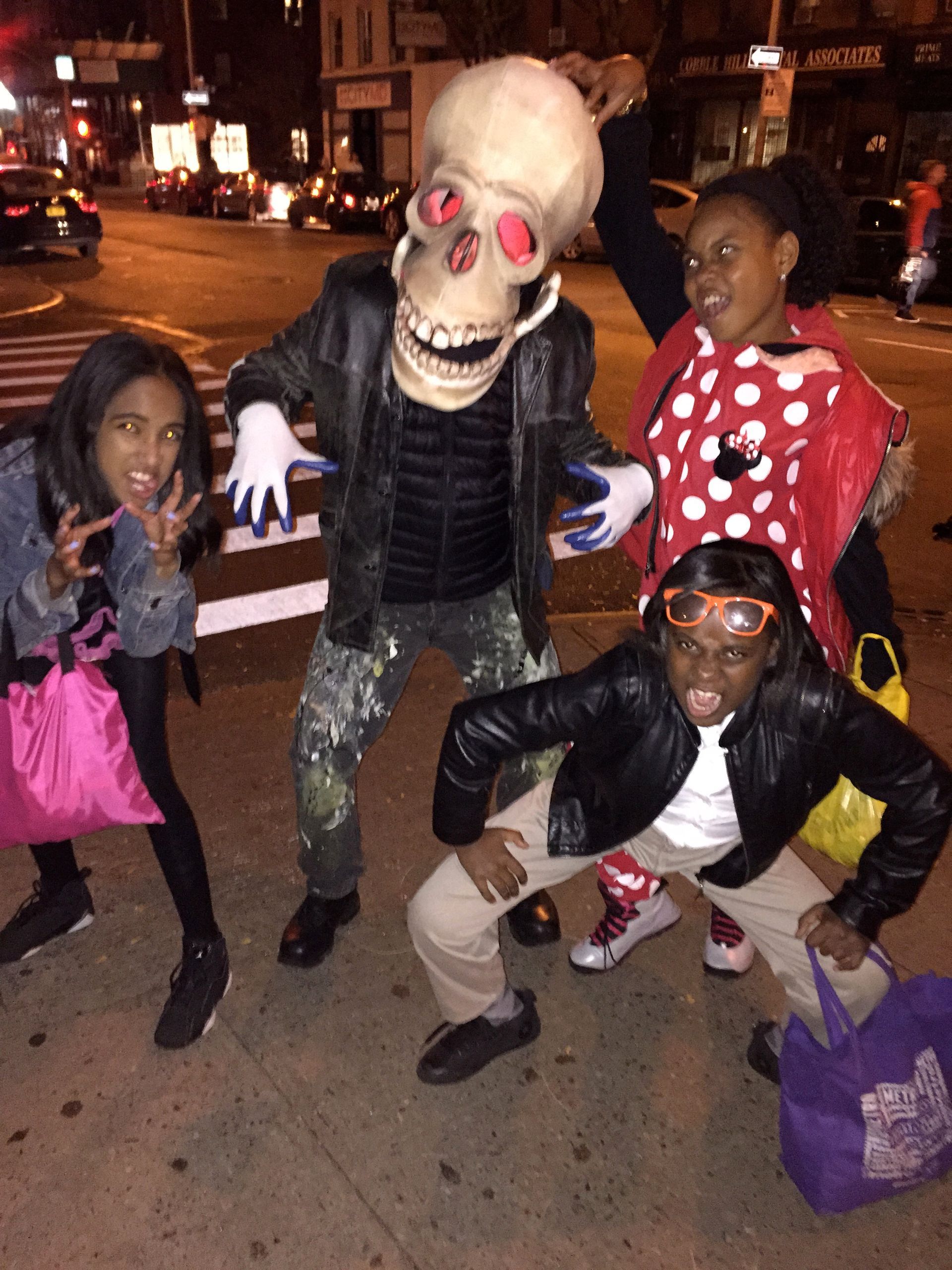 A group of children are posing for a picture with a man in a skeleton costume