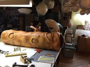A large piece of bread is sitting on a table in a room.