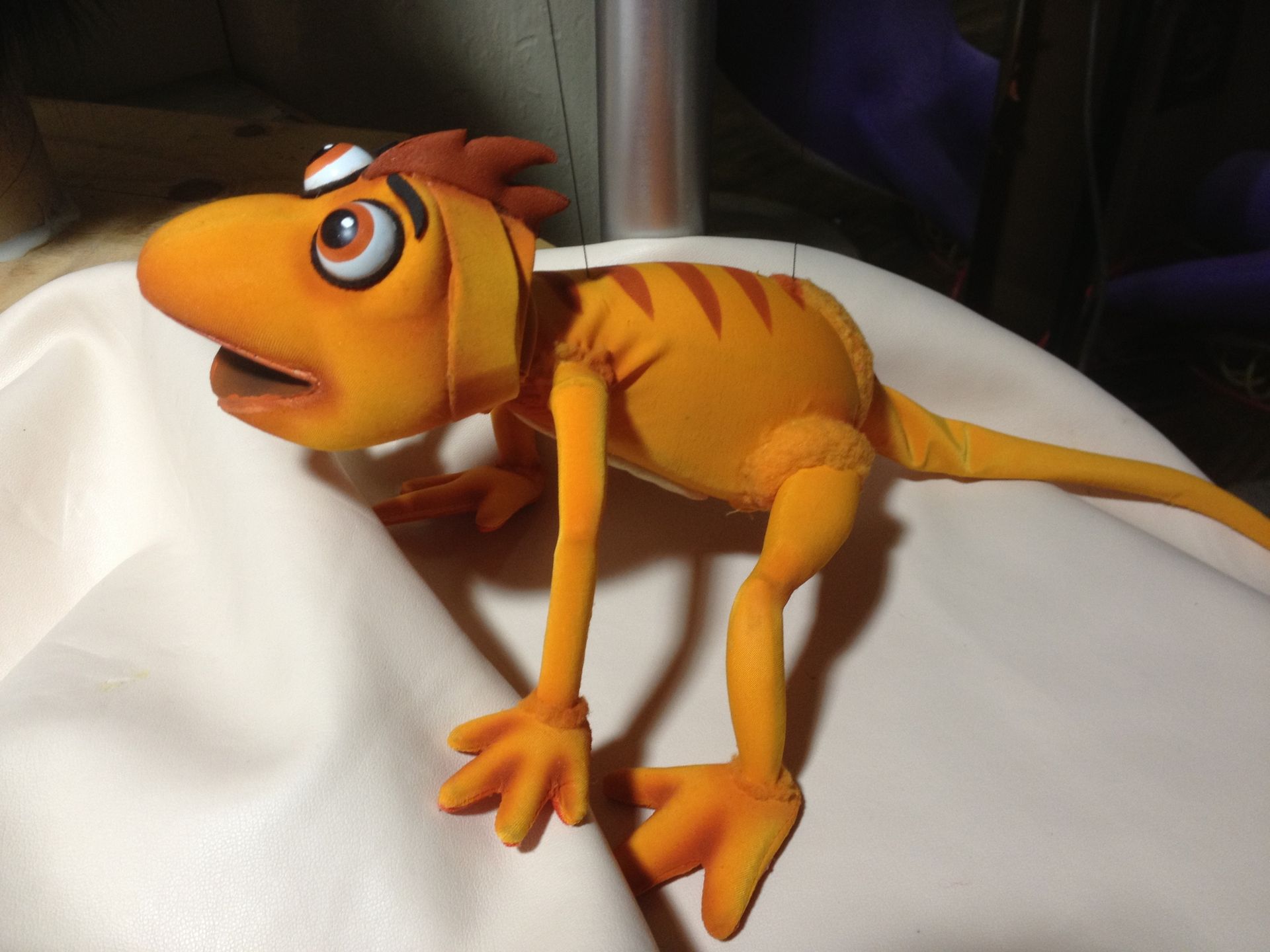 A cartoon lizard is sitting on a white cloth