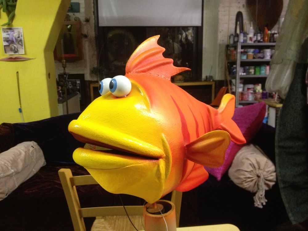 A cartoon fish is sitting on a chair in a living room