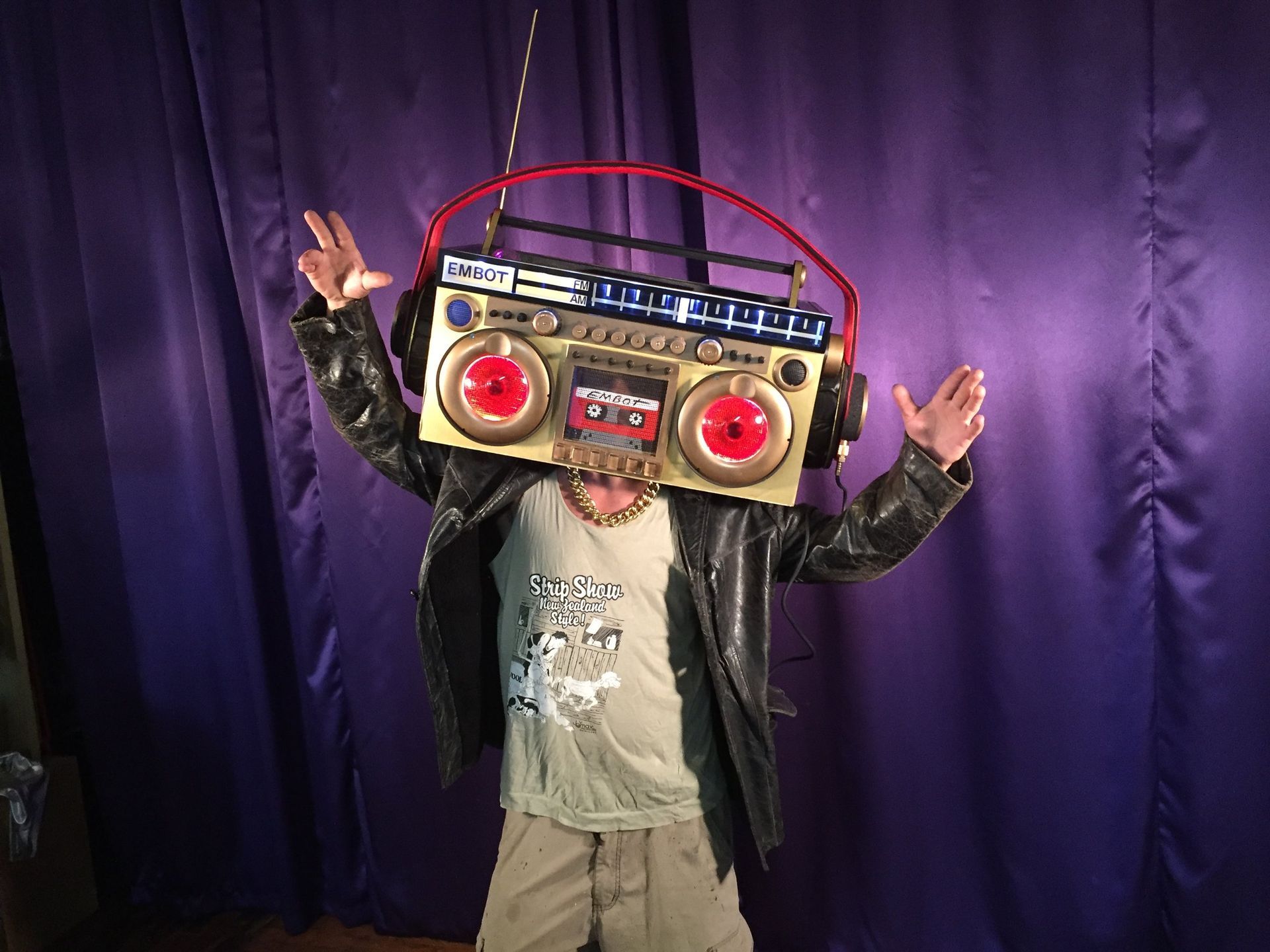 A man wearing headphones and a boombox on his head.