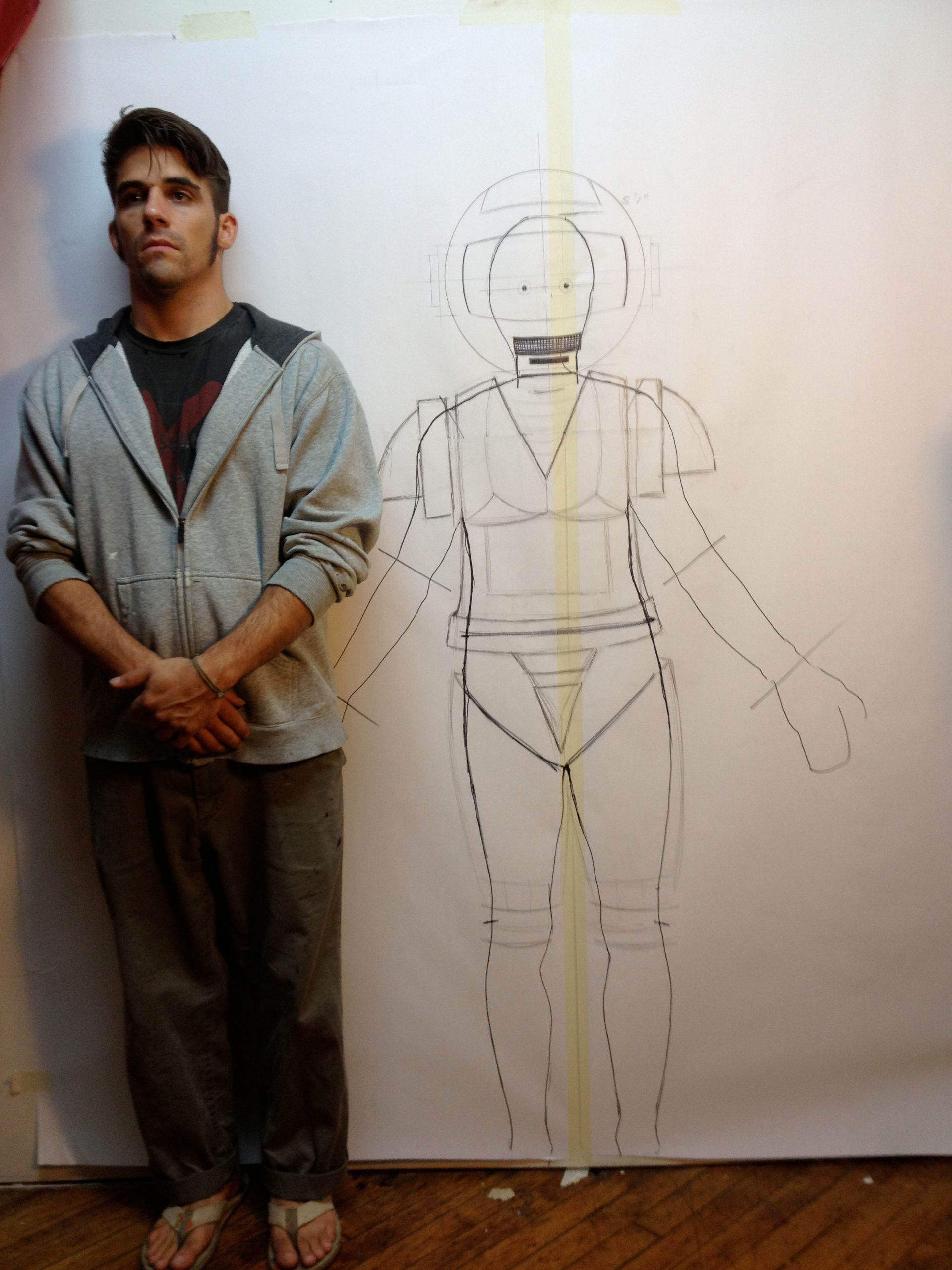 A man standing in front of a drawing of a woman
