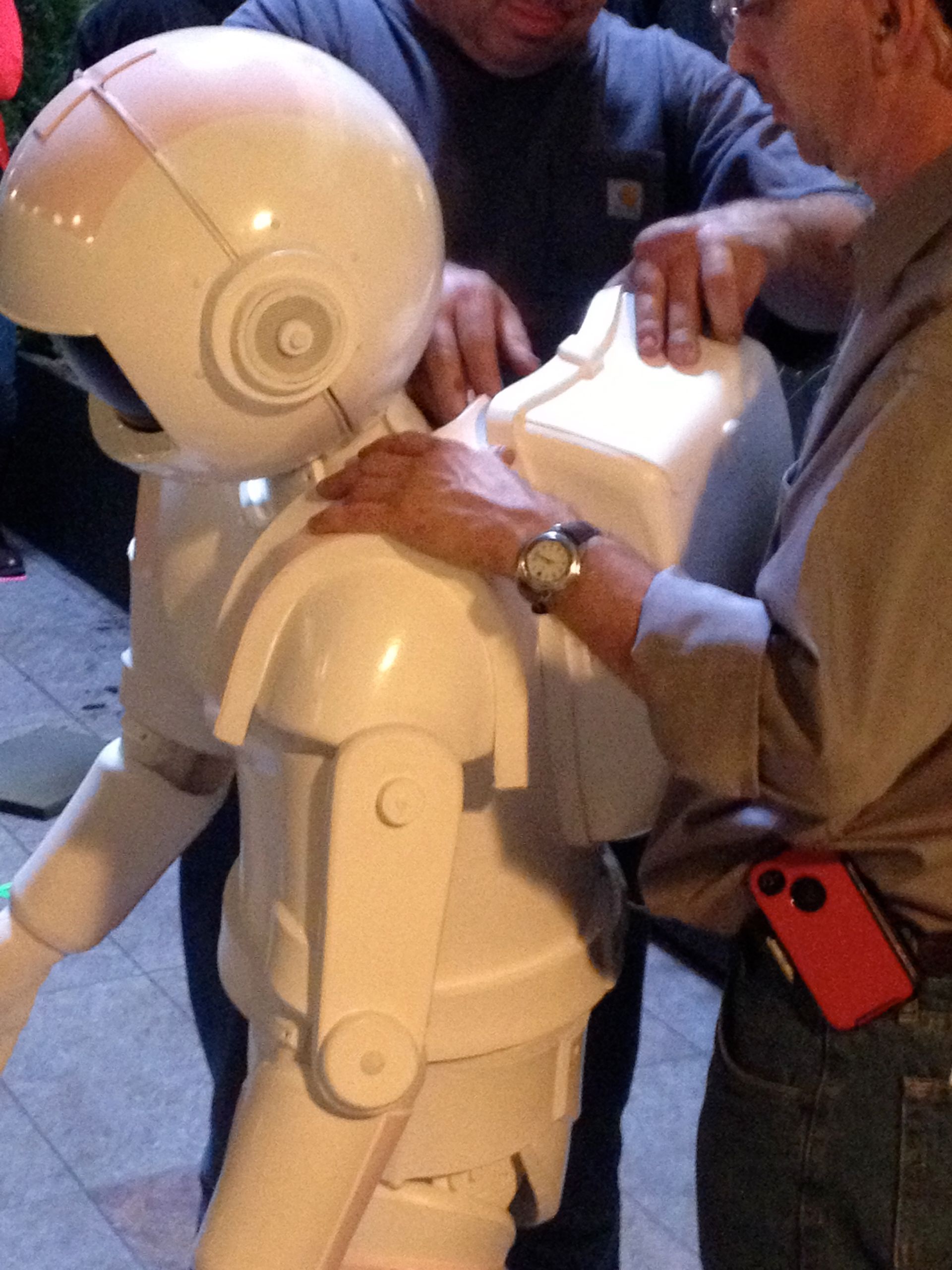 Two men are working on a statue of an astronaut