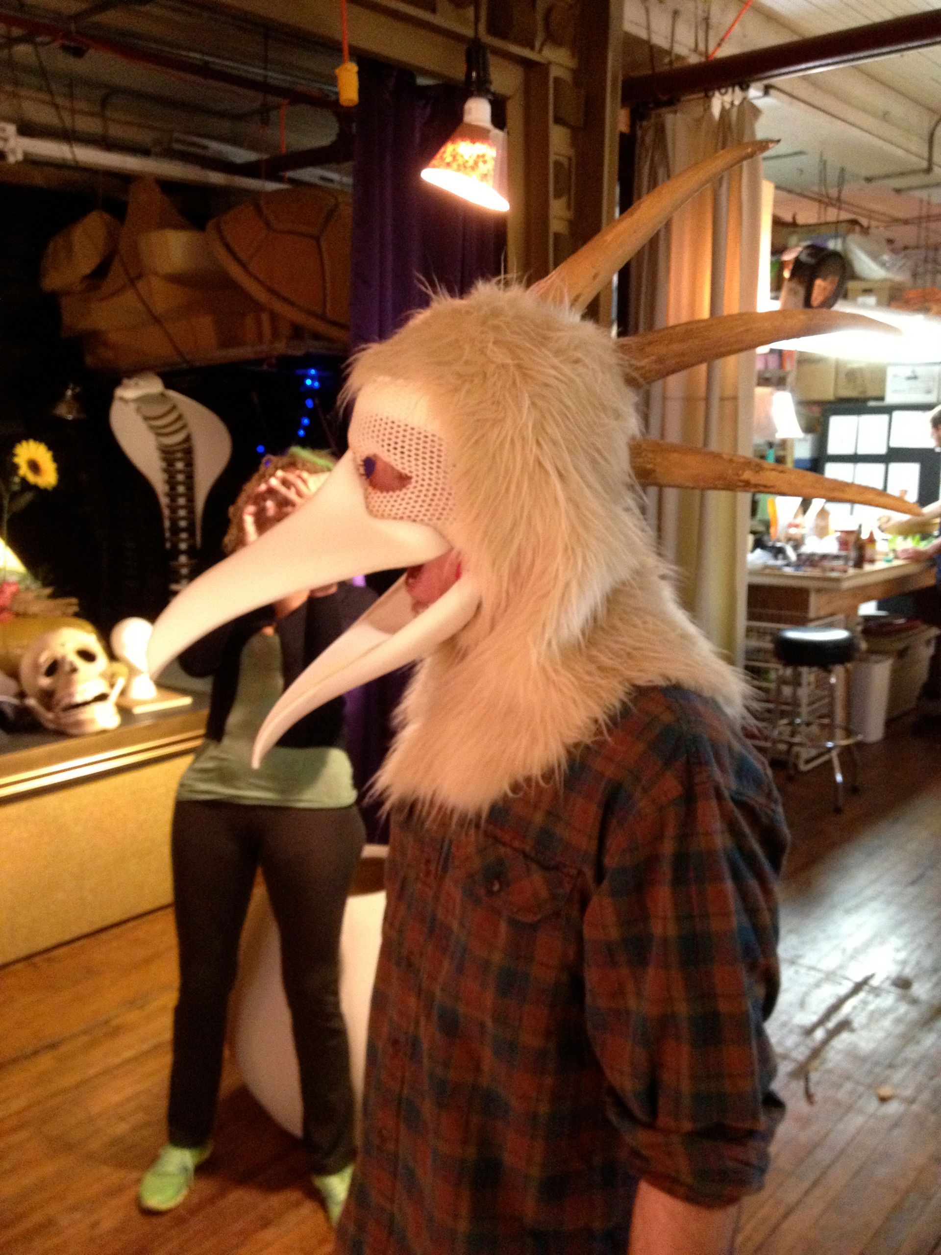 A man wearing a white mask with long horns