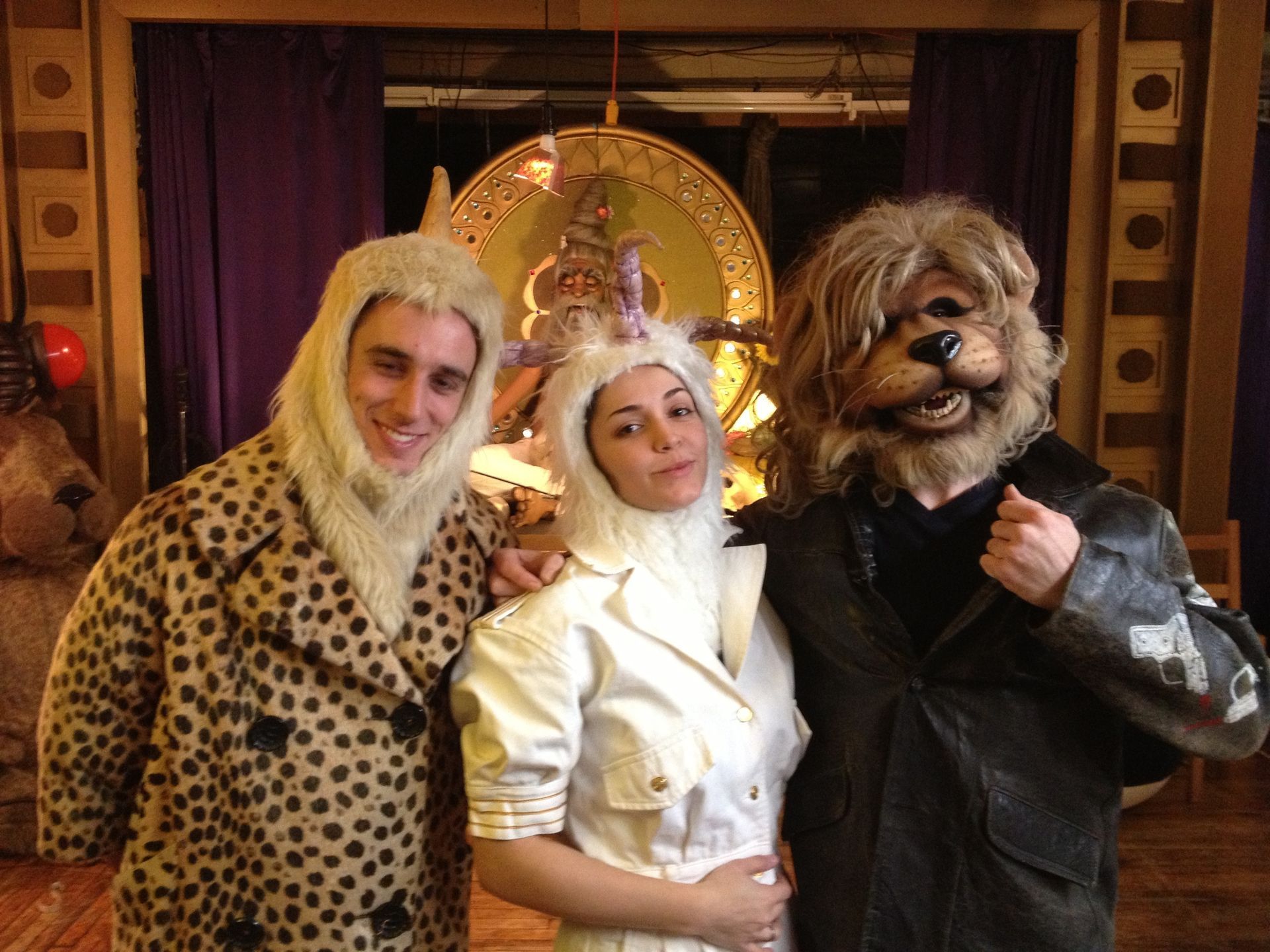 A man and a woman are posing for a picture with a man in a lion costume