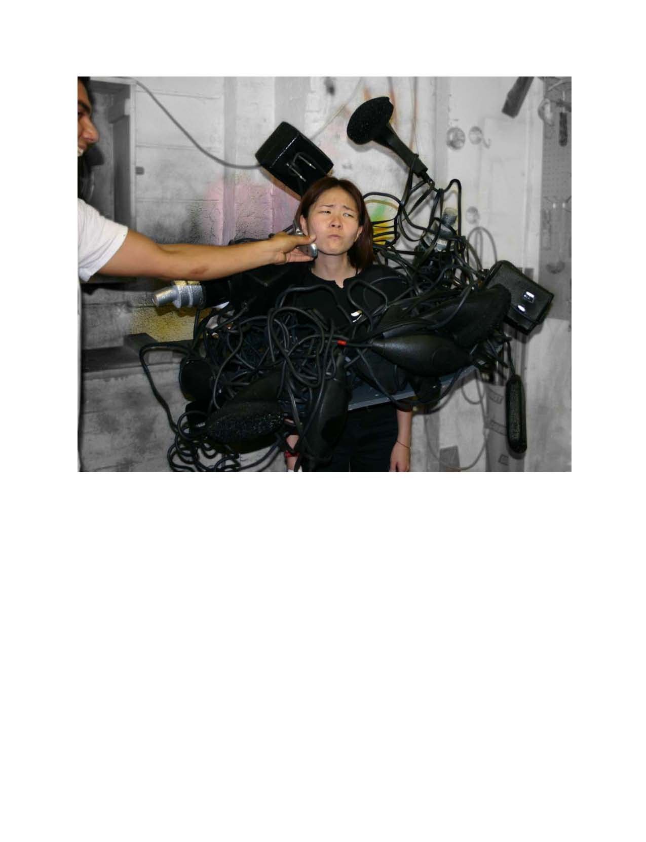 A man is brushing a woman 's hair in front of a bunch of wires.