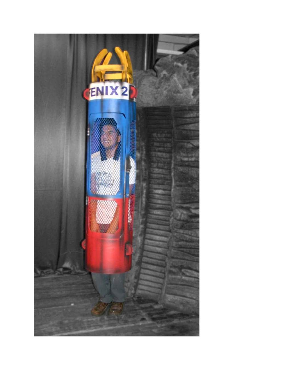 A man in a costume is standing next to a telephone booth.