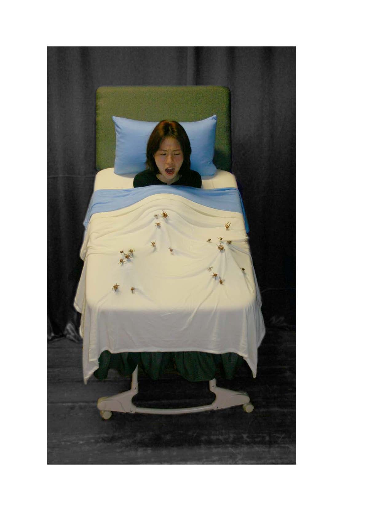 A woman is laying in a bed with a blue pillow