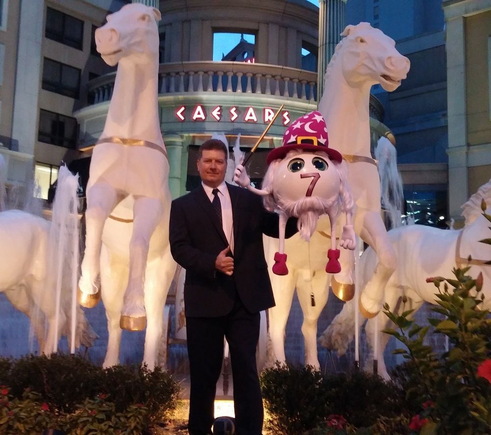 A man stands in front of a caesars sign
