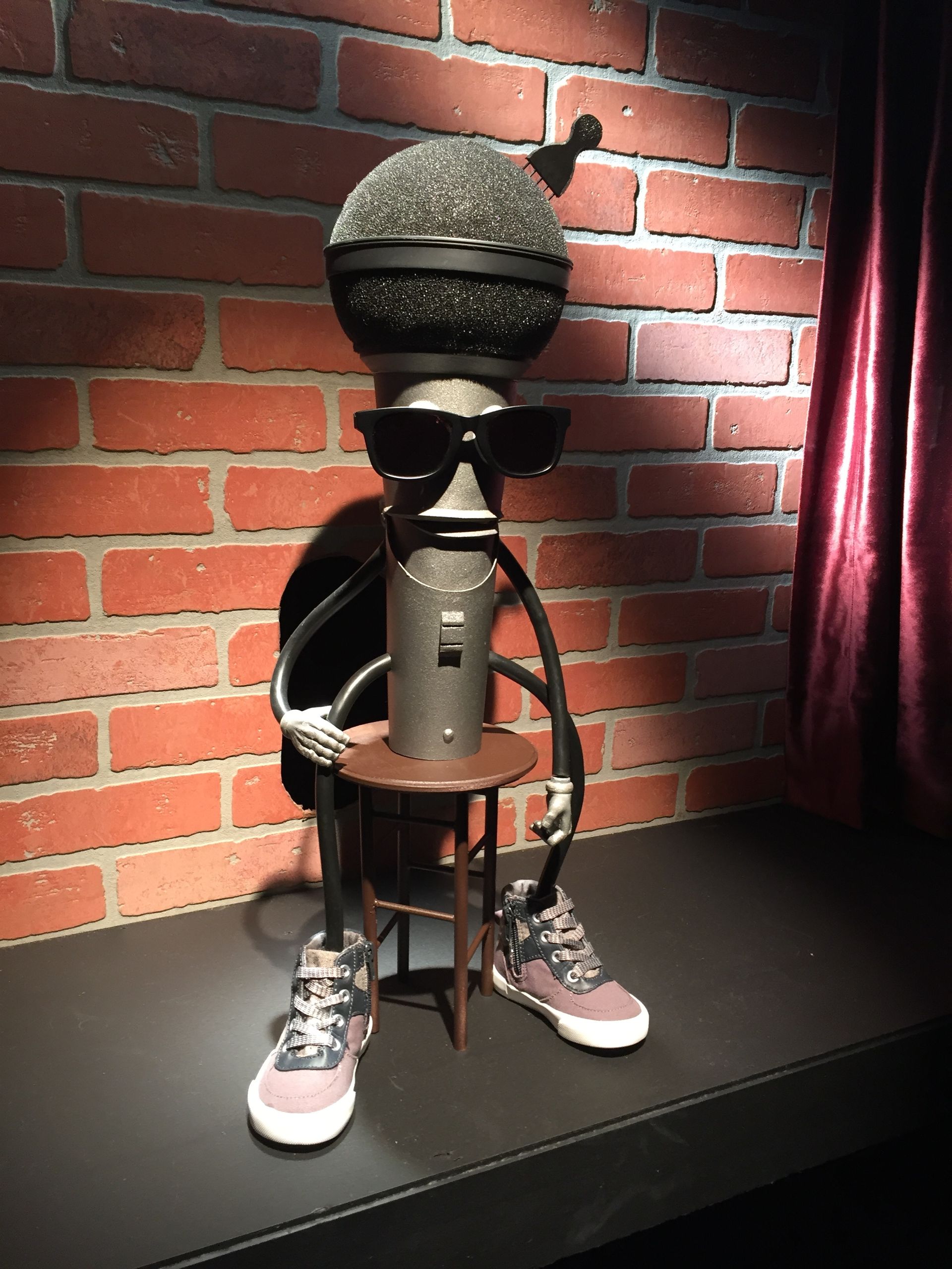 A statue of a microphone wearing sunglasses and sneakers