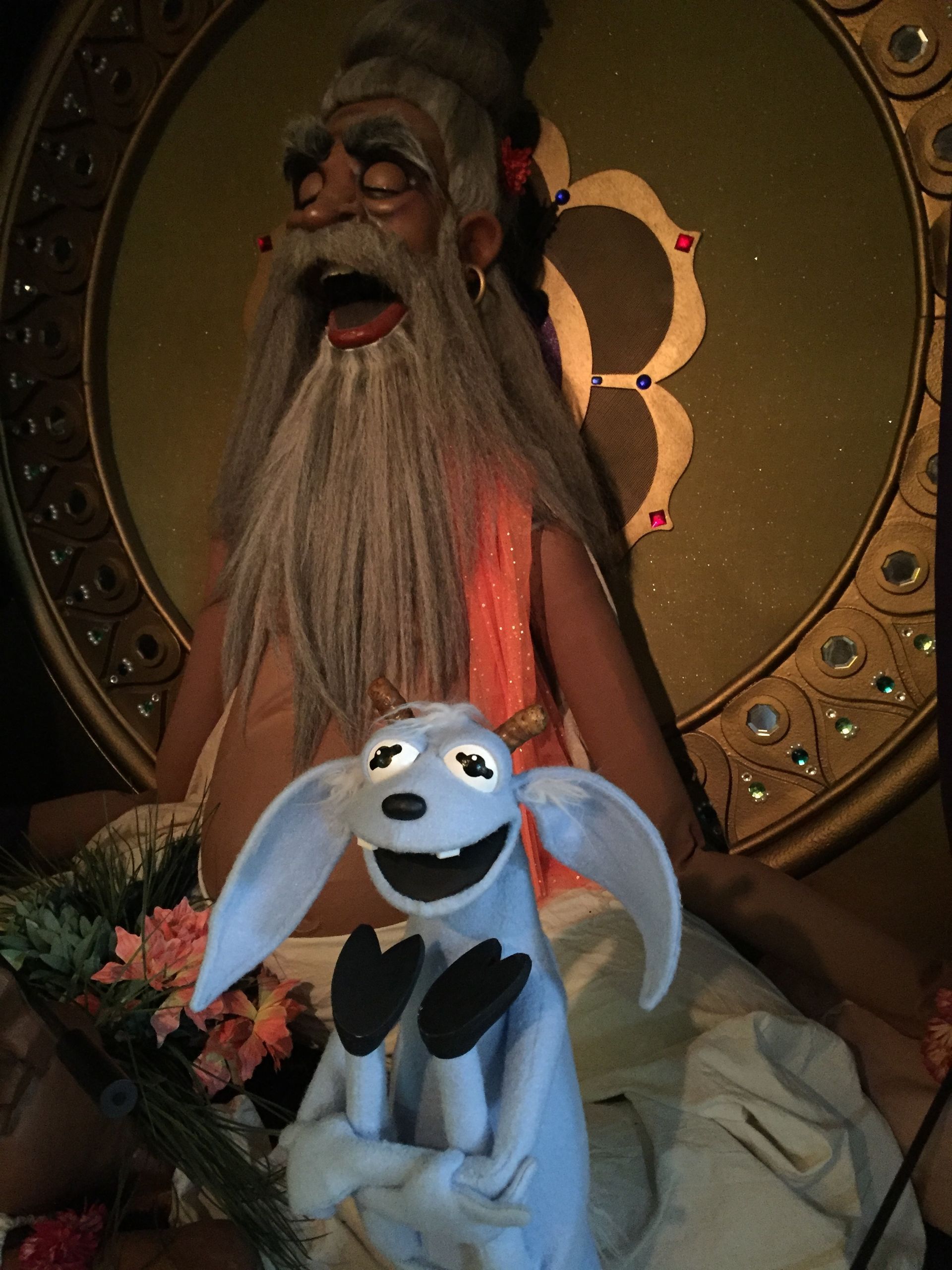 A statue of a man with a beard is next to a stuffed animal