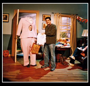 A man stands in front of a mannequin wearing a pink suit