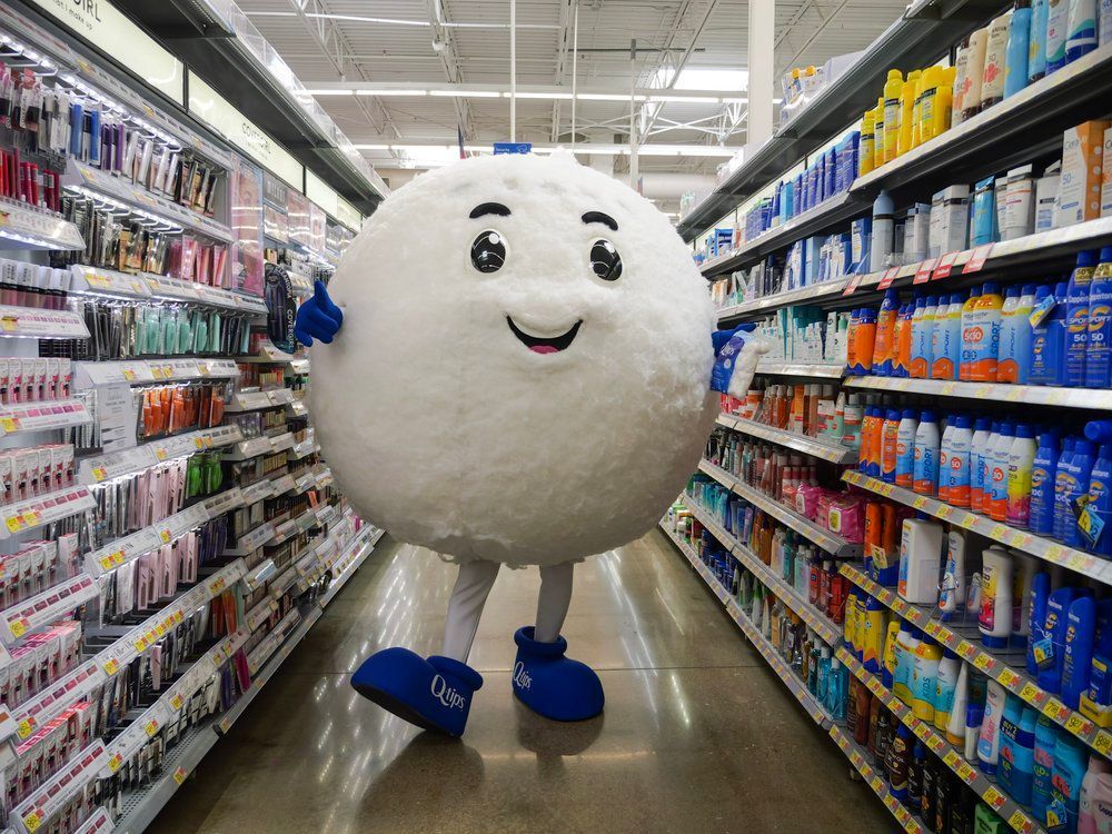 A mascot is standing in a grocery store aisle.