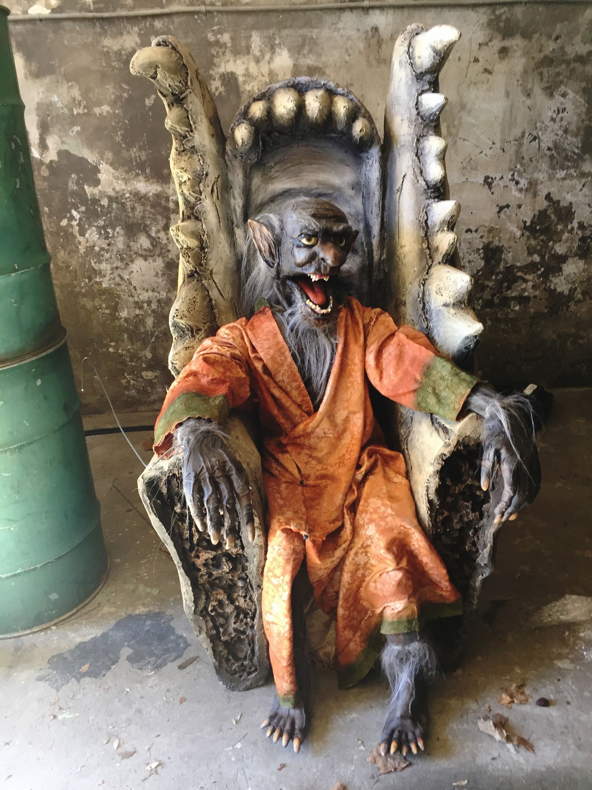 A statue of a werewolf sitting on a throne