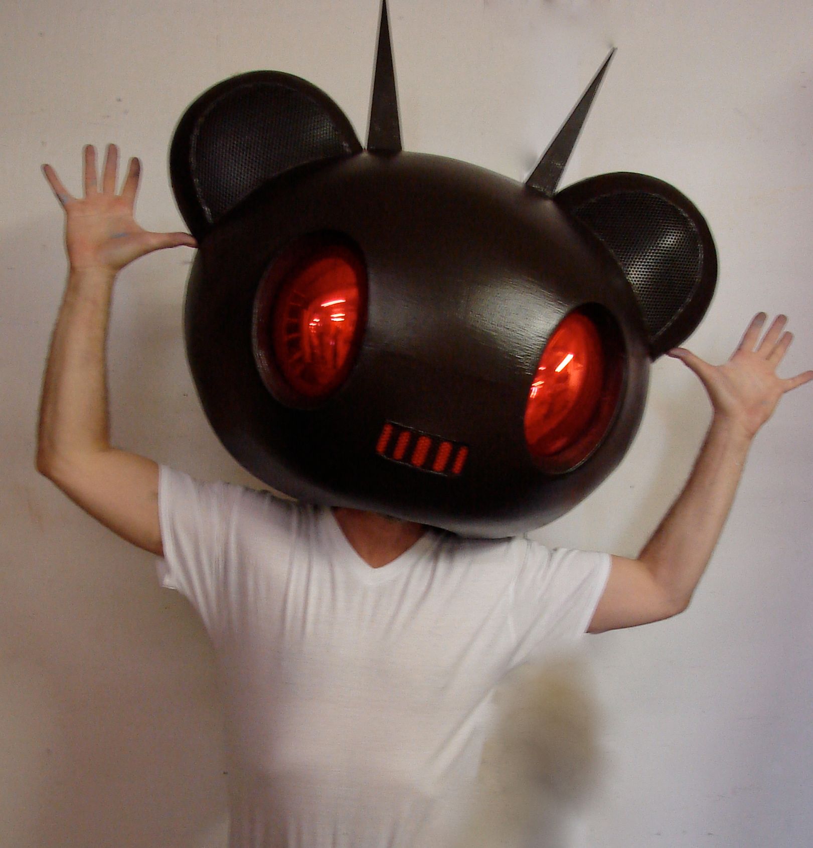 A person wearing a black bear head with red eyes