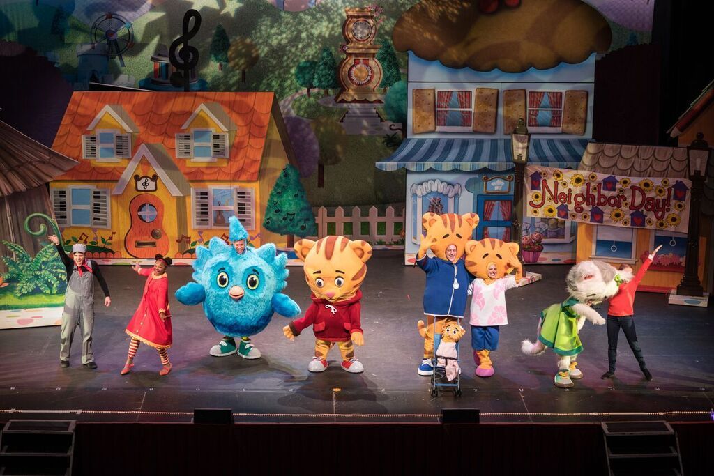 A group of cartoon characters are dancing on a stage.