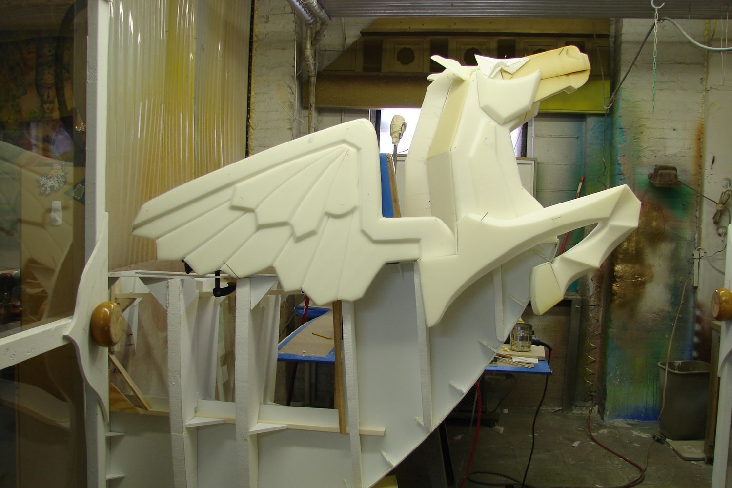 A foam sculpture of a winged horse is sitting in a room.