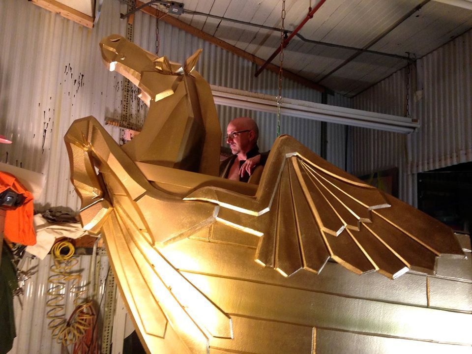 A man is sitting in a gold dragon shaped boat