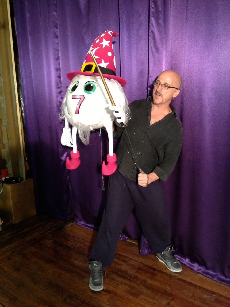 A man is holding a balloon with the number 7 on it