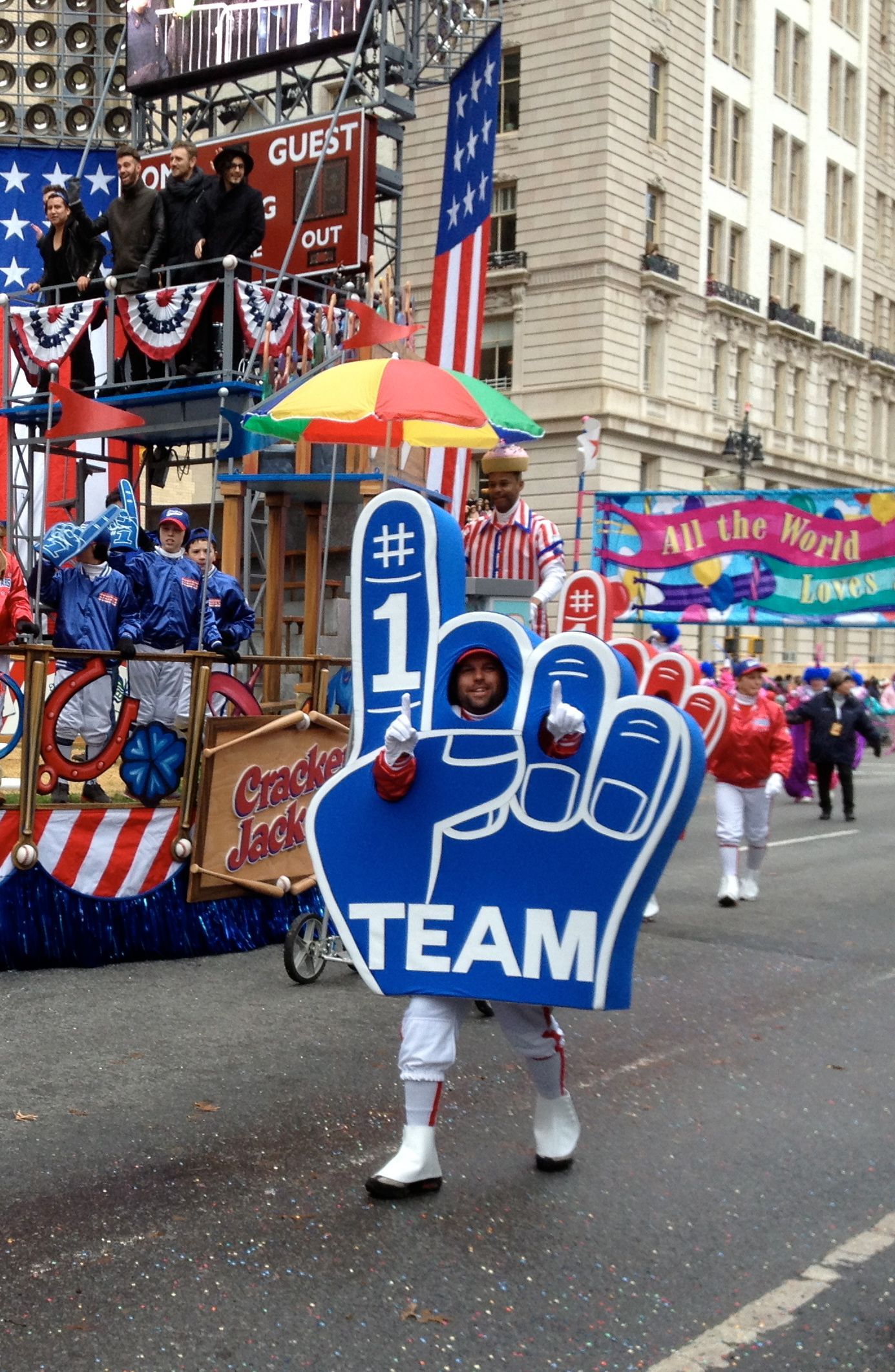 A person in a parade holding a foam finger that says team