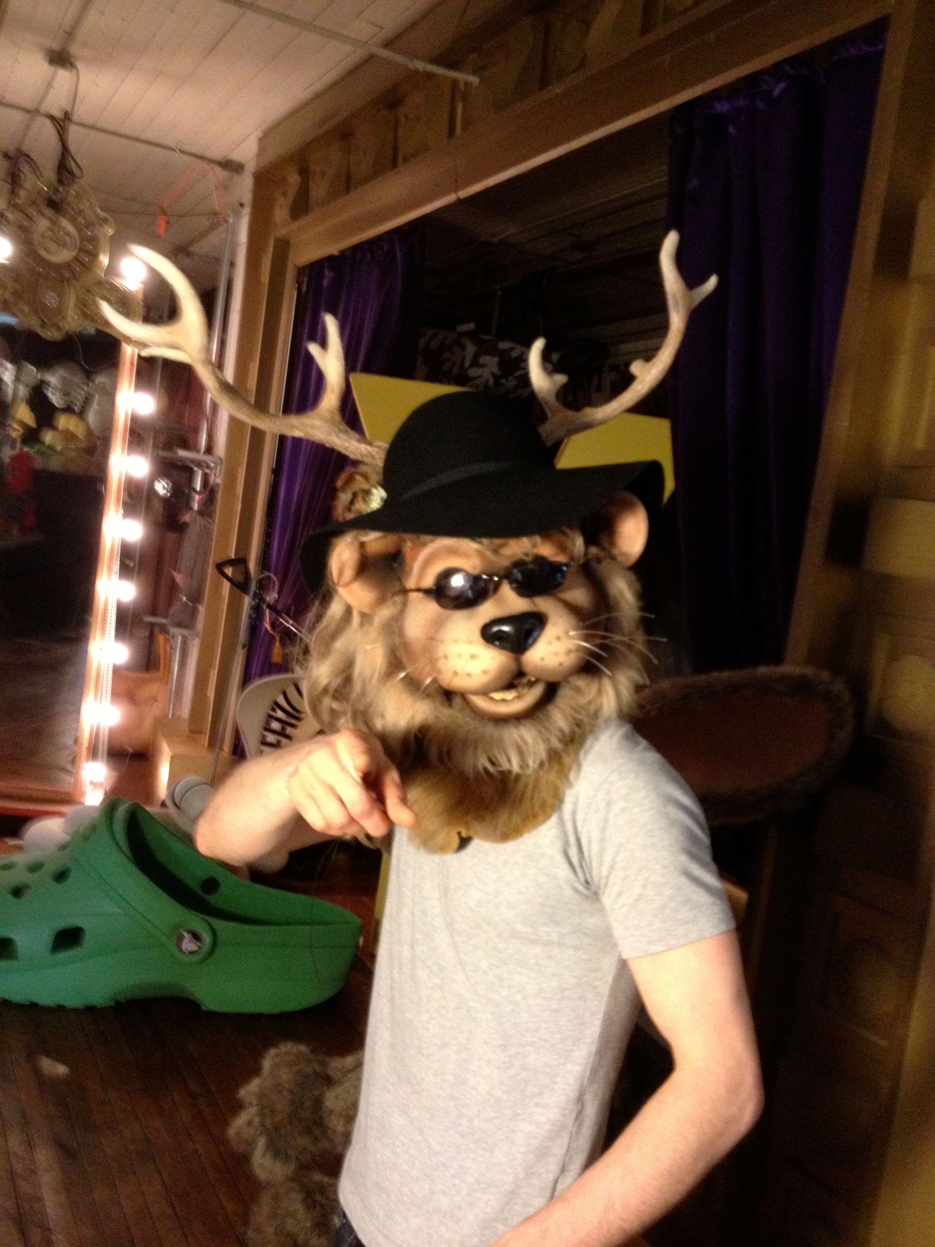 A person wearing a lion mask and a cowboy hat