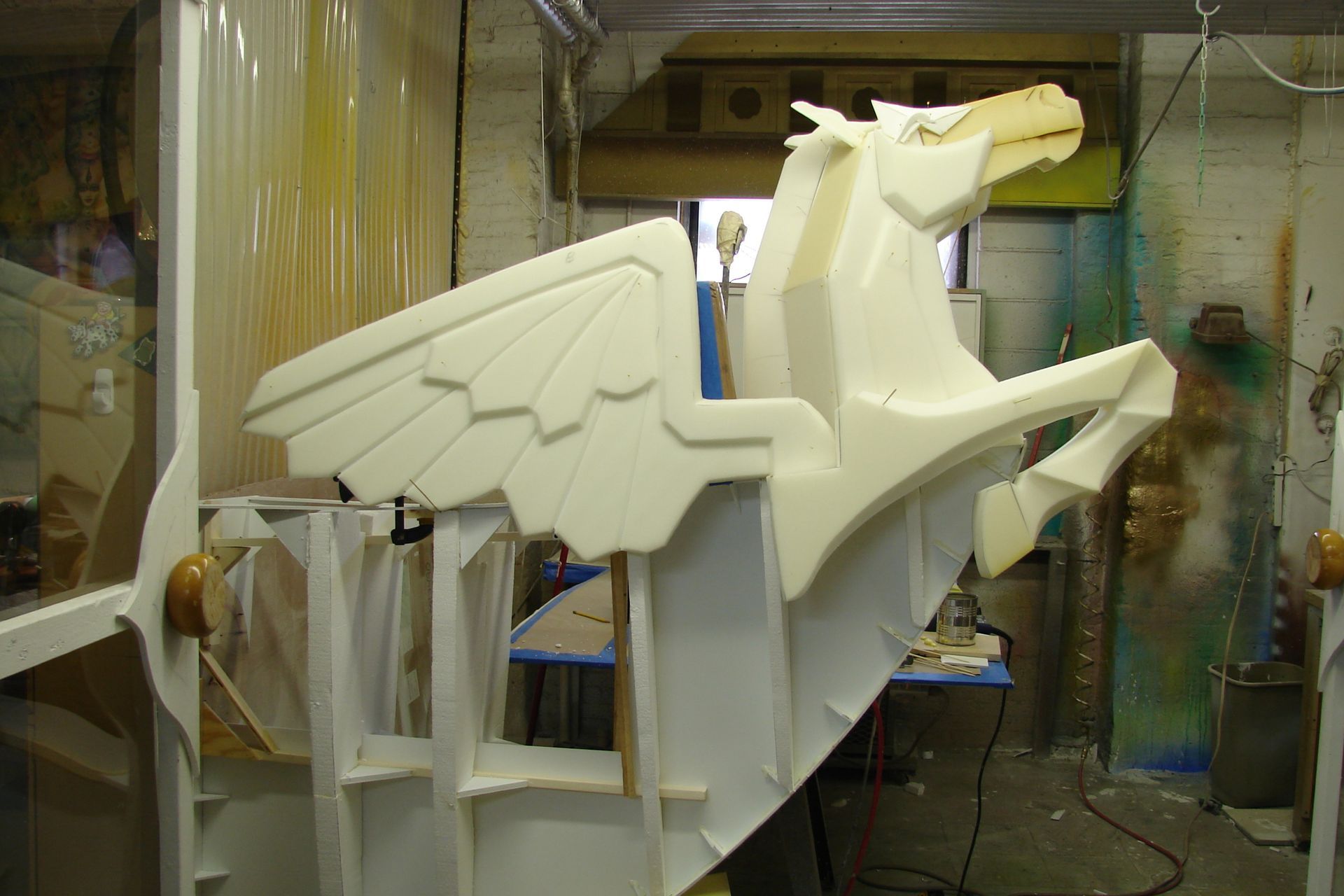 A foam sculpture of a pegasus is being built in a workshop