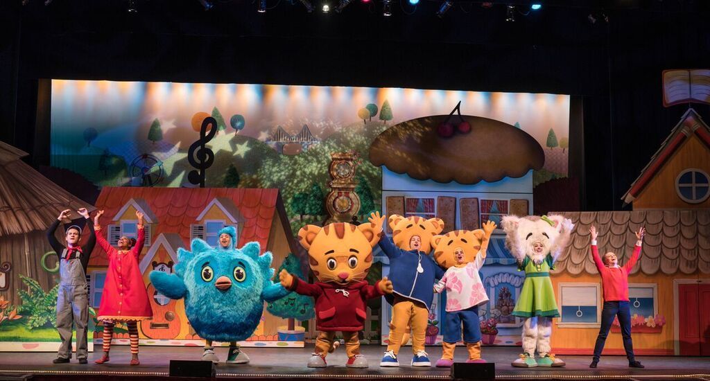 A group of cartoon characters are dancing on a stage.