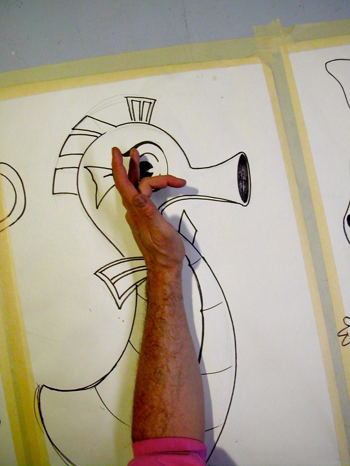 A person is drawing a seahorse on a piece of paper