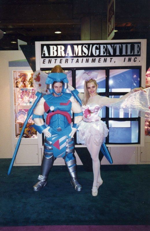 A man and a woman are posing in front of a sign that says abrams / gentile entertainment inc.